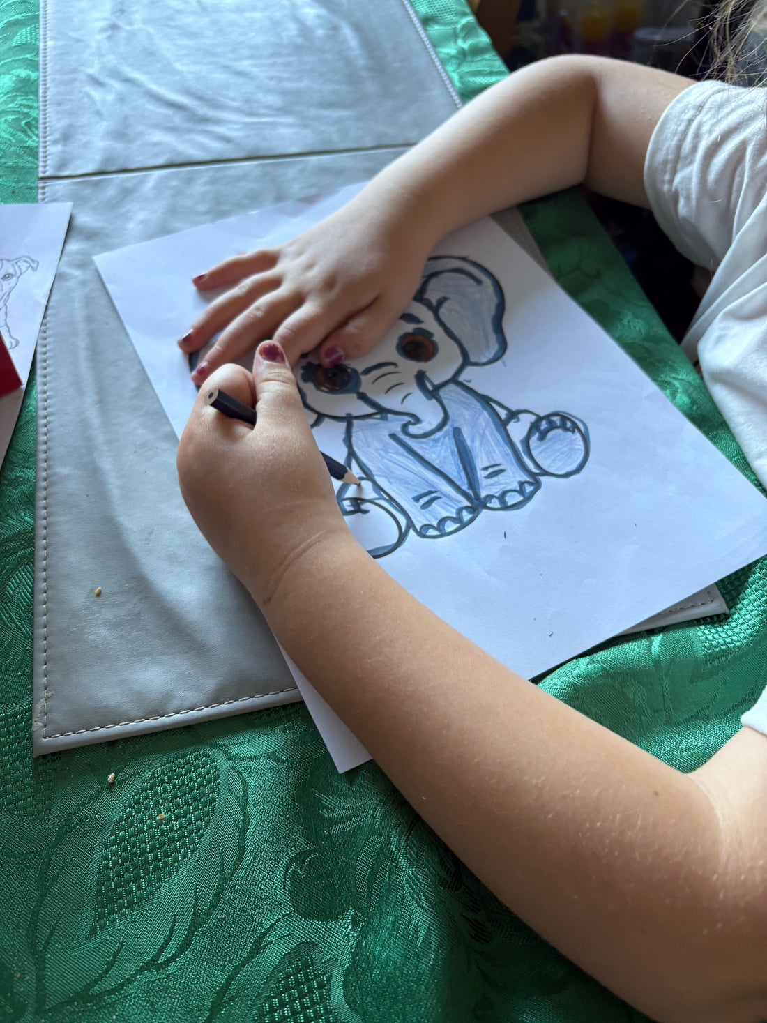 Children doing screen-free rainy day activities including colouring pages and crafts at home
