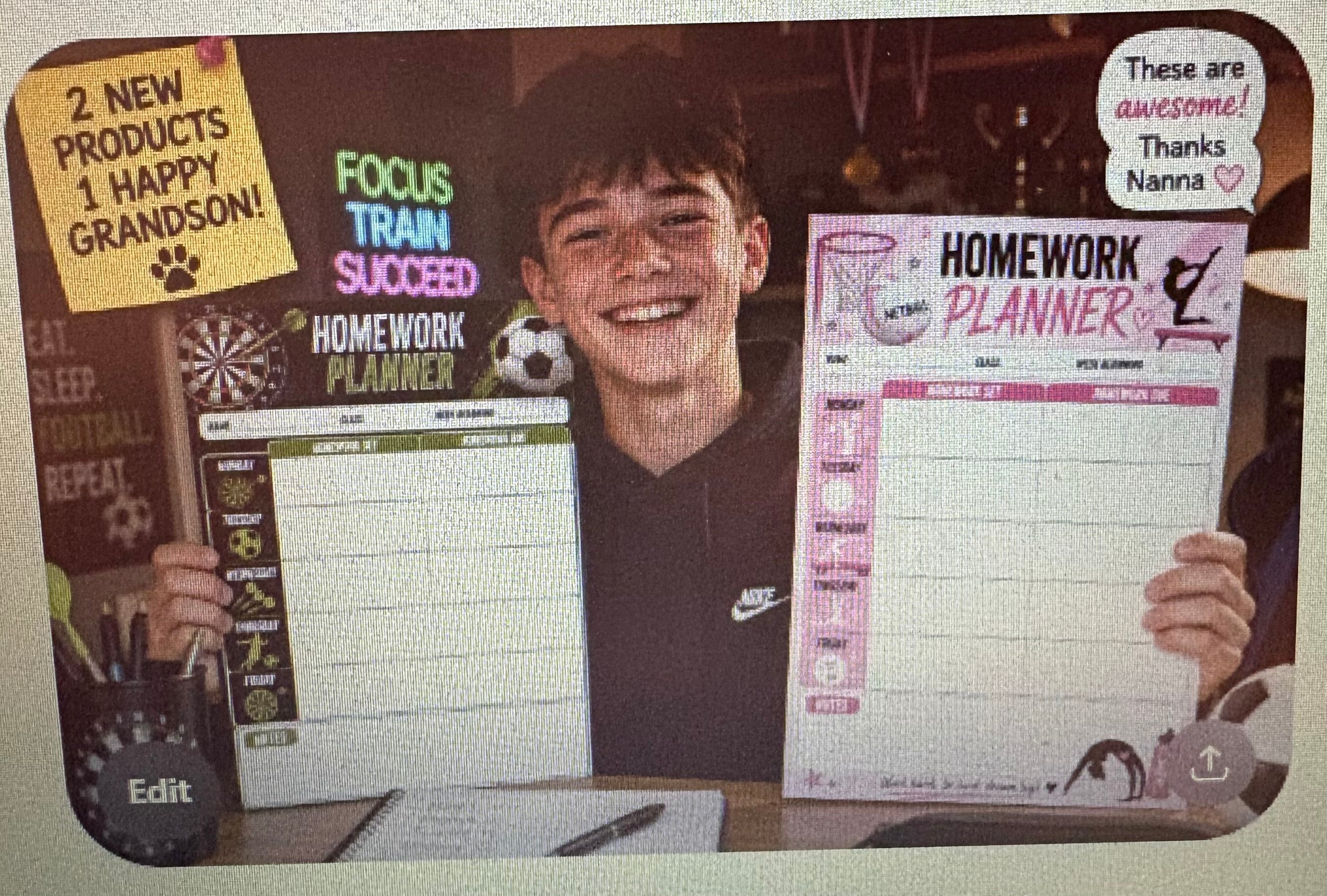 A teenage boy holding two printable homework planners — a darts and football planner and a pink netball and gymnastics planner — smiling at the camera.