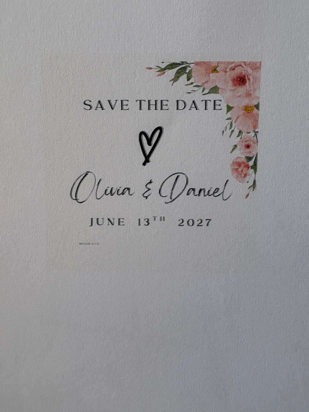 Save the date card with floral design and text on a light gray background