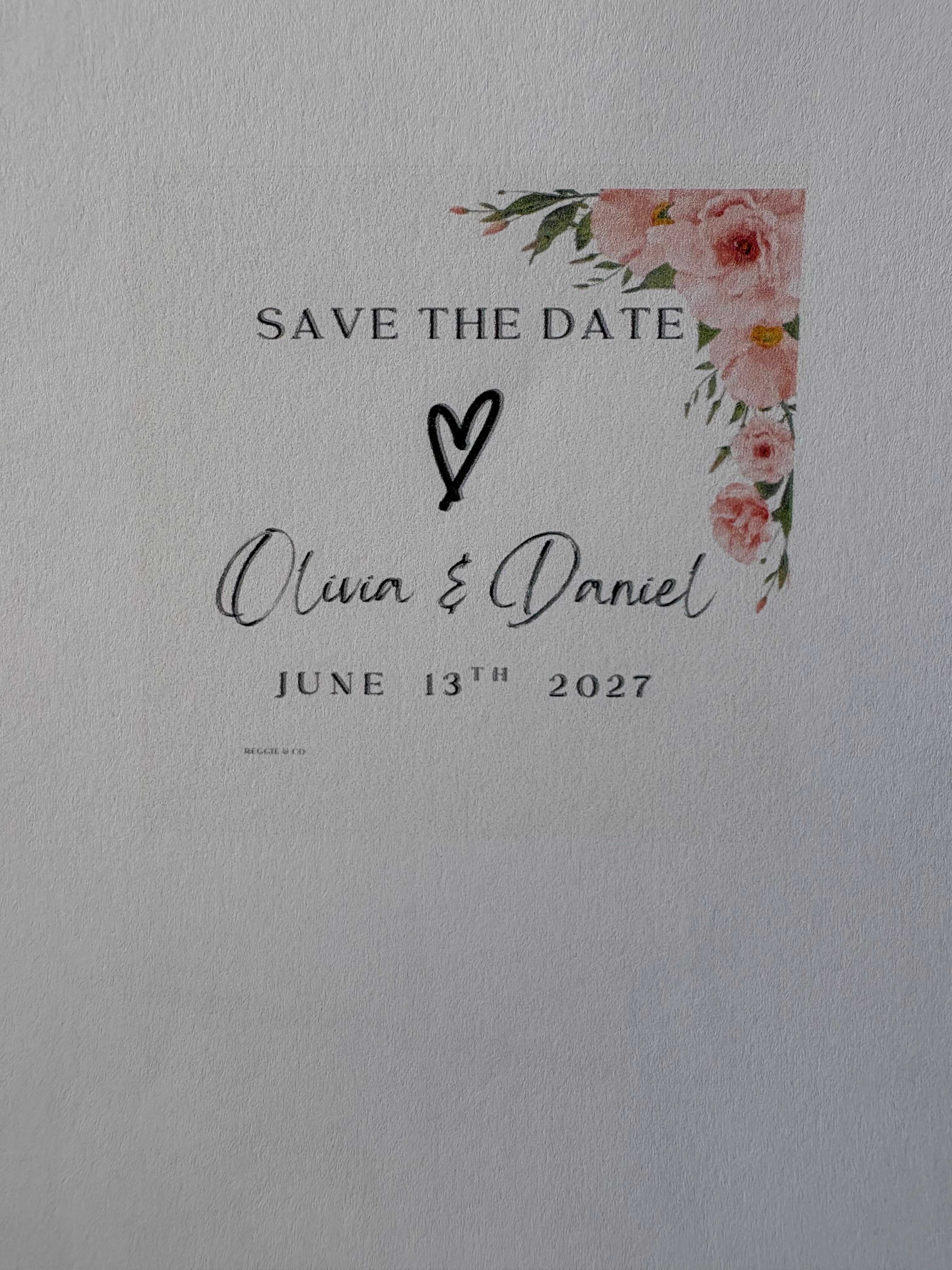 Save the date card with floral design and text on a light gray background